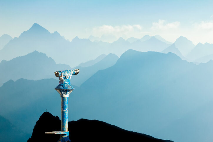 Public binoculars and Mountain Silhouettes at Sunrise. Foresight and vision for new business concepts and creative ideas. Alps, Allgau, Bavaria, Germany.